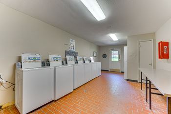 A room with a row of refrigerators and a fire extinguisher.